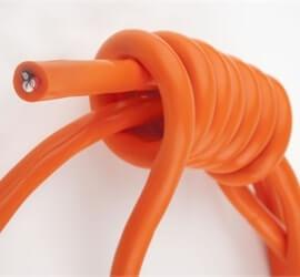view of flexible cable in orange tubing tied in a knot on a white background.